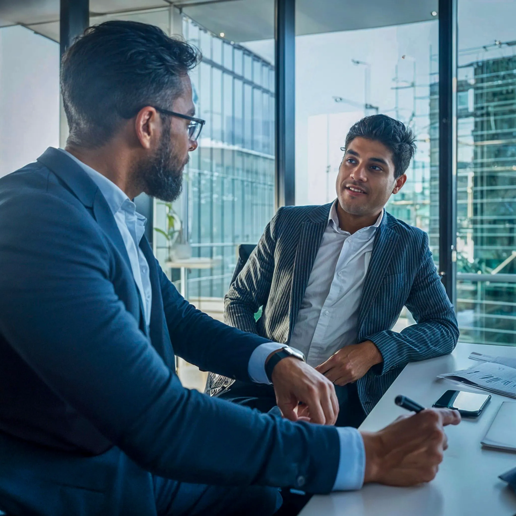 Reunión de negocios entre dos empresarios en una oficina moderna.